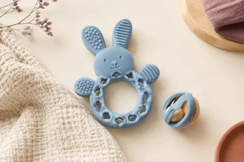 Anneau de dentition lapin bleu en silicone avec corps ajouré, reliefs à mordiller et hochet amovible