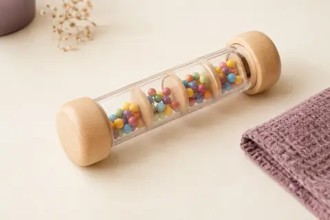 Bâton de pluie en bois avec des perles colorées visibles dans son tube translucide