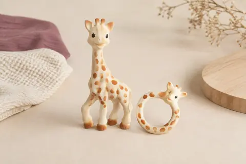 Girafe Sophie et anneau de dentition en caoutchouc naturel présentés sur un fond crème