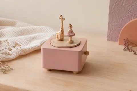 Boîte à musique en bois rose avec deux figurines aimantées sur sa piste de danse
